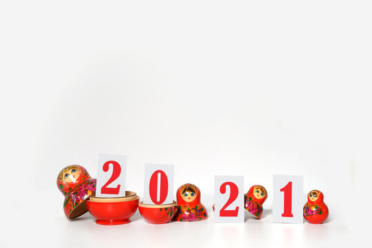 red christmas numbers 2021 combined with russian nesting dolls on isolated white background. russian doll matryoshka Holiday decoration or postcard concept with top view and copy spac