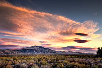 Cumulus and Cirrus Clouds Over a Mountain during Sunrise