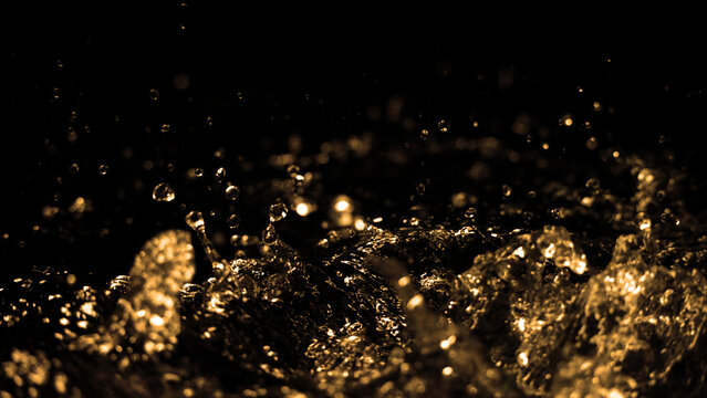 Hi speed close up images of oil liquid from diesel gasoline splashing and moving up to the air on black background for represent power of fuel liquid that active and powerful. studio shot premium gold