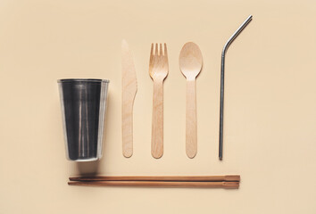 Eco cutlery with cup on color background