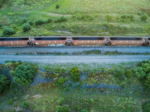 Coal train passing by on railroad seen from above full of coal to export
