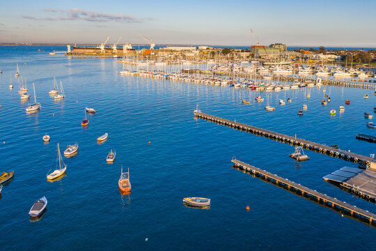 Aerial view a bay side yacht club with long jettys out over the water