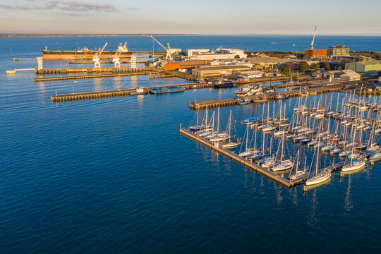 Aerial view of a bay side yacht club with rows of boats lined up along jetties