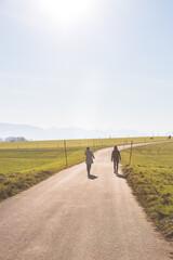 Obraz premium Two people are walking on asphalted road