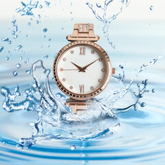 Luxury women's watch in water splashes demonstrating its waterproof