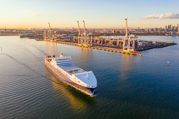 Aerial view of a cargo ship leaving a city port