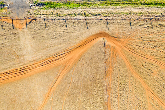 Aerial view of animal track going through a farm gateway along a fence line