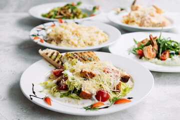 Assorted salads on white plates in a restaurant top view