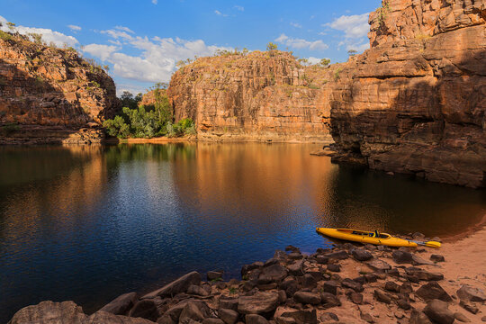 Golden light on pool of water in Nitmiluk Gorge with canoe