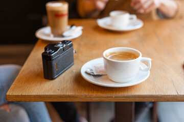 Coffee and photography meetings concept with natural light at a wooden table coffeeshop.