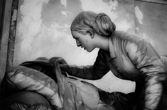 Una statua che rappresenta una veglia funebre su una tomba del cimitero monumentale di Staglieno a Genova