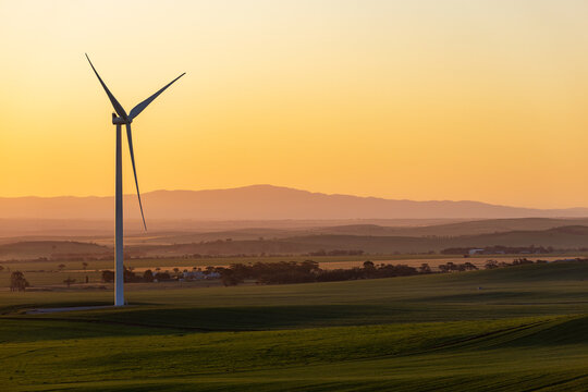 single wind turbine against golden afternoon sky