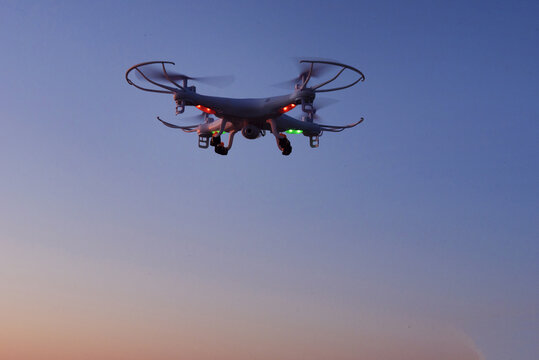 Flying drone in air at sunrise over mountain