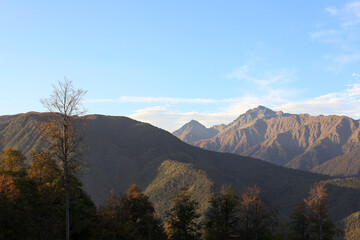 Beautiful bright panorama of the mountain landscape at sunset against the background of the blue sky