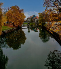 Obraz premium a beautiful reflection of the trees on the river in the old city