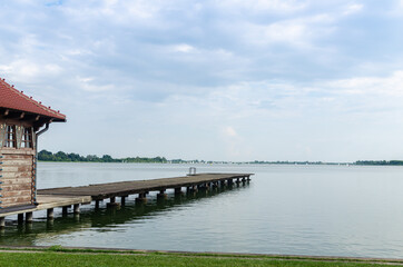 Mole in a lake with calm surface under cloudy sky