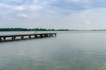 Mole in a lake with calm surface under cloudy sky