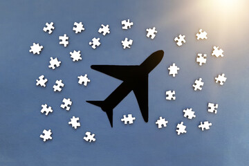 The plane is black, the puzzles are white on a blue background. Travel, tourism, air travel.