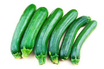 Multitude of green courgettes in a row on a perfect white background