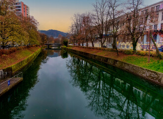beautiful reflection of the trees on the river in the old city