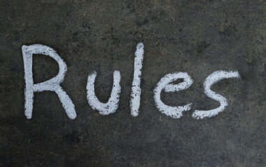 Rules Word Written on Blackboard with White Chalk