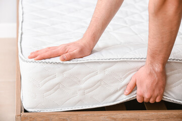 Man choosing orthopedic mattress in store