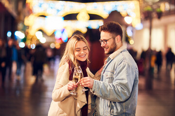 Couple drinking champagne and celebrating New Year at the street. New year party.