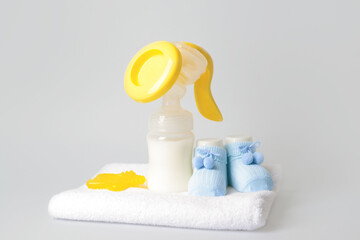 Breast pump and baby accessories on grey background