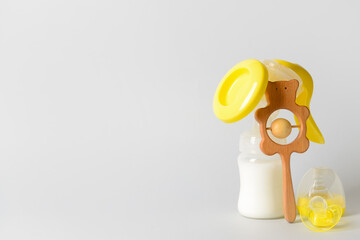 Breast pump and baby accessories on grey background