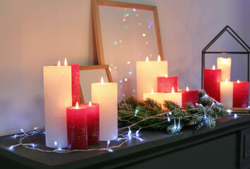 Candles and Christmas decor on mantelpiece in room