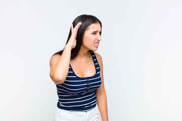 young woman looking serious and curious, listening, trying to hear a secret conversation or gossip,...
