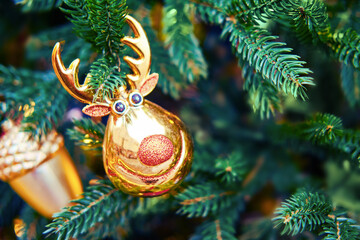 Glass elk and acorn hanging as decorations on a Christmas tree, close-up