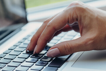 Hands writing ond a keyboard of a laptop or a notebook in Home Office