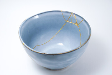 Blue kintsugi bowl. Gold cracks restoration on pottery restored with the antique Kintsugi restoration technique. The beauty of imperfections. representation of trauma. 