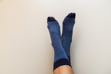 woman legs in new blue socks on a light beige background