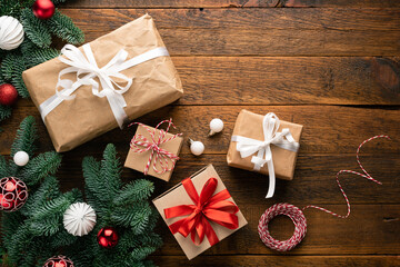 Christmas or New Year background with presents covered in craft paper on wooden background. Top view copy space for text or design