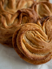 Homemade sweet bun with cinnamon and sugar on white paper background