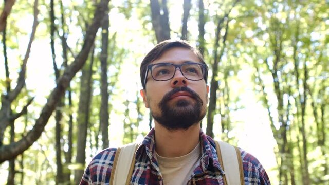 Standing alone in the forest in the open air against a forest background. close-up portrait face. Traveling Concept People in Nature. Hiker Journey in Wildlife