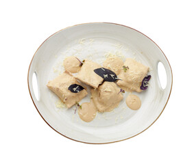 Dumplings or vareniki with mushroom sauce isolated on white