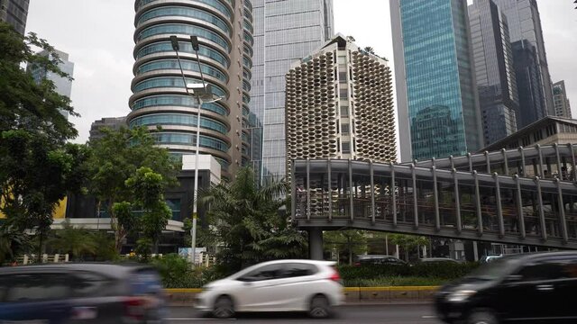 jakarta city day time downtown traffic street famous modern pedestrian bridge slow motion panorama 4k indonesia