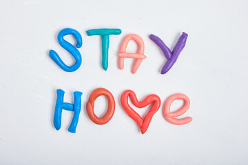 inscription stay home from plasticine on a gray background