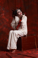 The art of depression. Studio portrait of young female model performing as an old clown suffering from pandemic lockdown and isolation. Pandemic stress conception