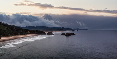 Obraz premium Cannon Beach, Oregon, United States. Beautiful Aerial Panoramic View of the Rocky Pacific Ocean Coast. Dramatic Cloudy Sunrise Sky.