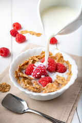 breakfast with brown rice flakes, milk and fresh raspberries