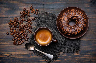 on the rustic wooden background, yummy breakfast with espresso and chocolate glazed donuts