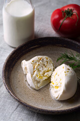 Fresh italian soft buratta on handmade plate with bottle of milk 