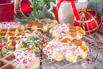 Stack of homemade Belgian waffles for Christmas breakfast. Traditional waffles dipped in white chocolate, with Candy Cane crumbs and festive sugar sprinkles