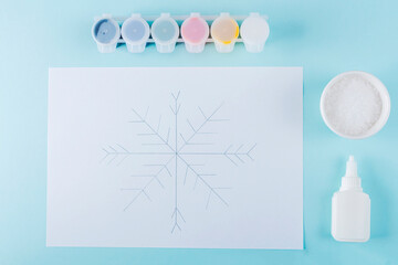 Concept of DIY and kid's creativity. Step by step instruction: how to make snowflake from glue and salt on paper. Step 2 snowflake sketch by pencil for children Christmas and New year craft