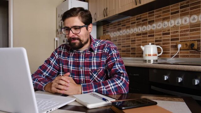 Young man freelancer student using laptop studying online working from home in internet, smiling focused millennial guy typing on computer surfing web looking at screen enjoying distant job