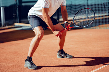 Fototapeta na wymiar Tennis player standing in ready position on tennis court